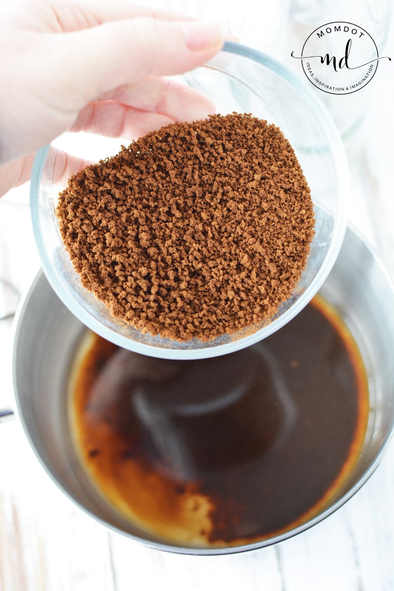 Adding instant coffee to a pot of boiling water to make homemade Kahlua.