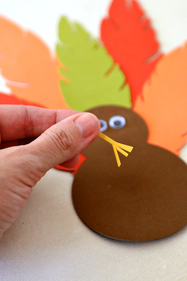 A cardstock turkey foot cut with scissors and ready to be glued onto a turkey hat