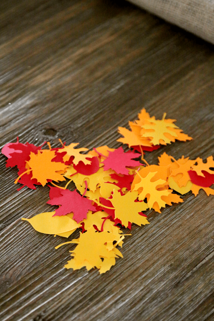 Fall leaves cut from paper in colors of yellow, orange, and red to decorate Thanksgiving handprint poem craft.
