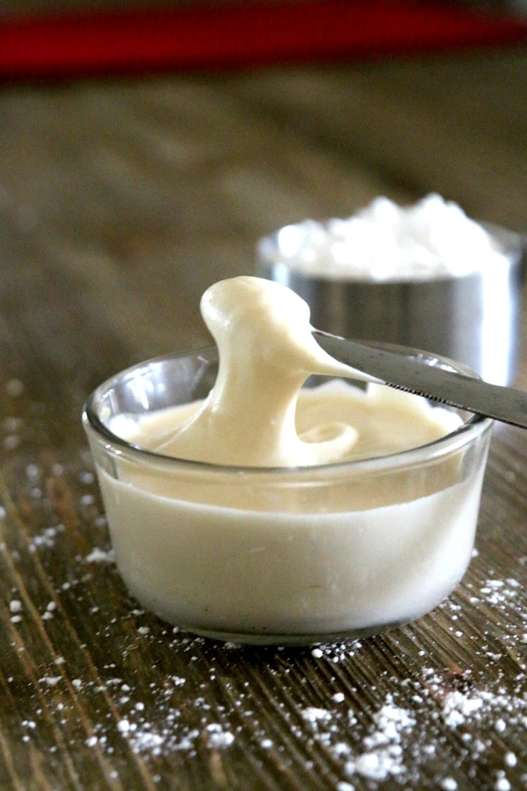 2 Ingredient Butter Cream Frosting Recipe in a small dish with a knife dipping in to show the creamy texture.