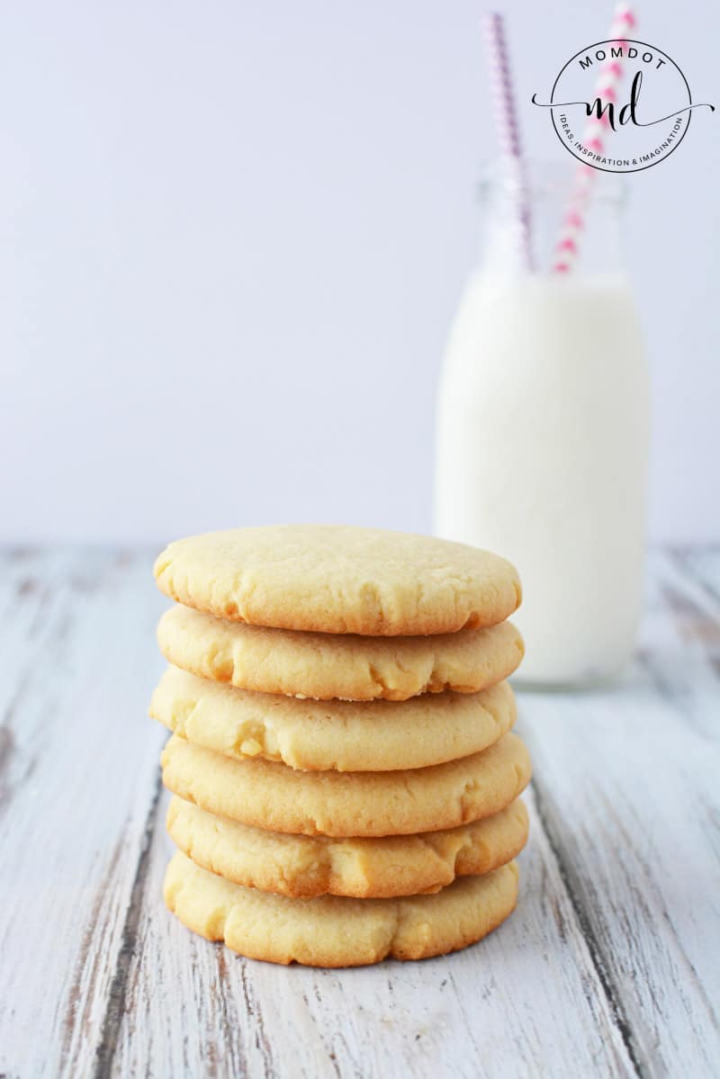 6 Country Crock sugar cookies in a stack with a glass of milk.