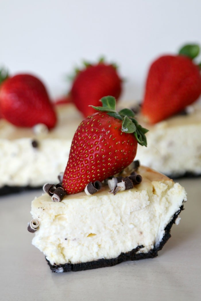 Original Philadelphia cheesecake in a chocolate cookie crust with chocolate curls and a fresh strawberry on top