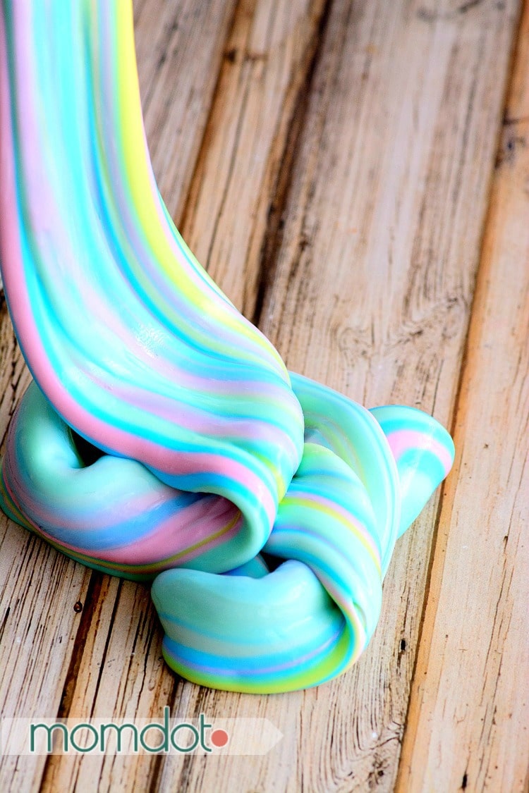 Rainbow unicorn poop slime being swirled on a table.