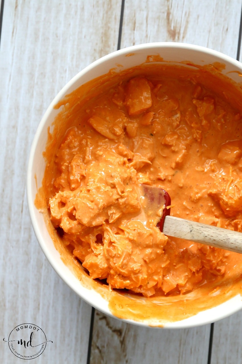 chicken and hot sauce being mixed together to make buffalo chicken dip