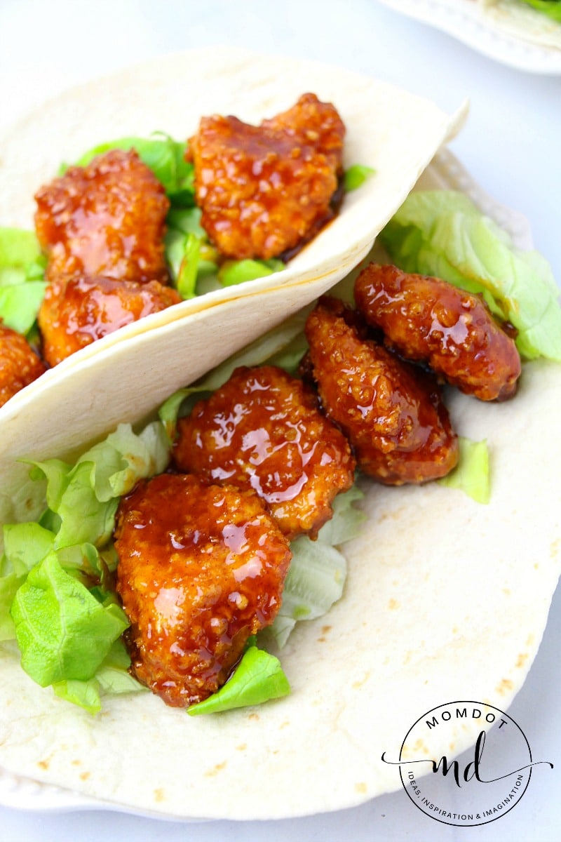 tortillas with lettuce and perfectly spicy breaded chicken tenders on top 