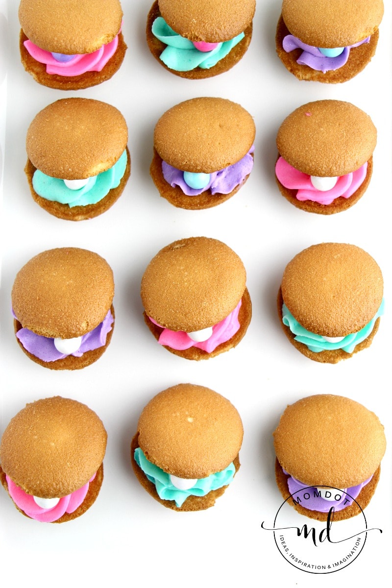 Finished clam shell cookies have the Nilla wafers offset so you can see the colored frosting and candy pearl from the top