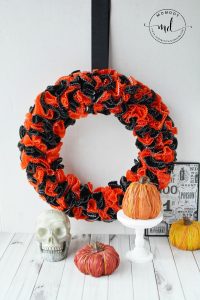 How to make a Halloween wreath with cupcake wrappers, which is perfect for mantel or hanging in your home. You will find a step by step DIY tutorial below for your cupcake wrapper wreath. Have fun!