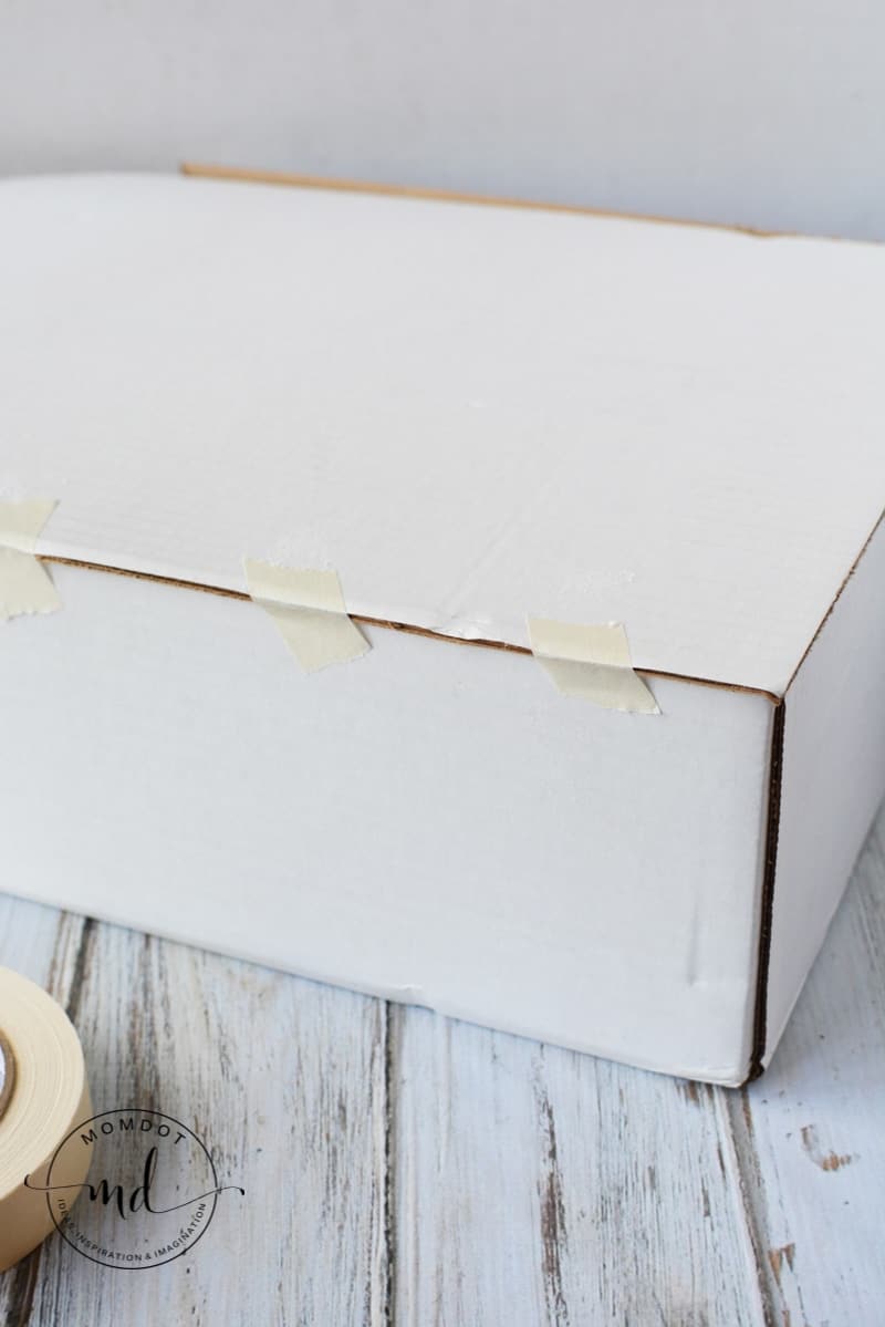 Masking tape holding together a cardboard box to make a fake tombstone
