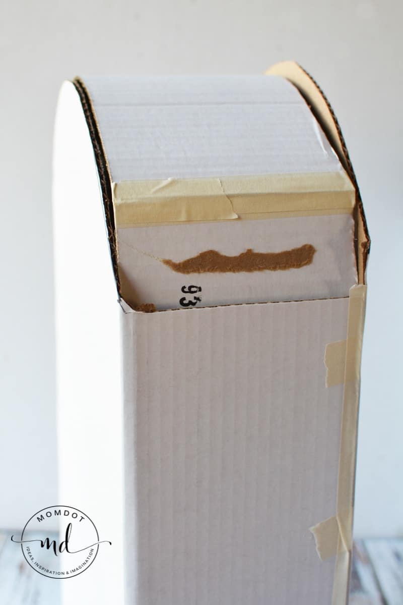 Top of a cardboard tombstone being taped together for a DIY decoration
