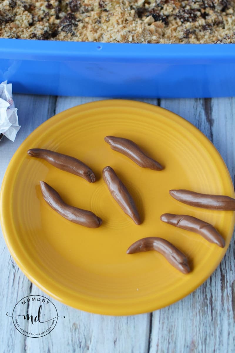 Melted Tootsie Rolls shaped into cat poop shapes to decorate the top of the kitty litter cake.