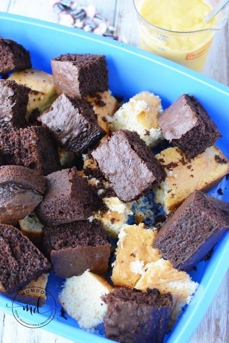 The chocolate and vanilla cake is cubed and placed into the litter pan for assembling the cake and serving.
