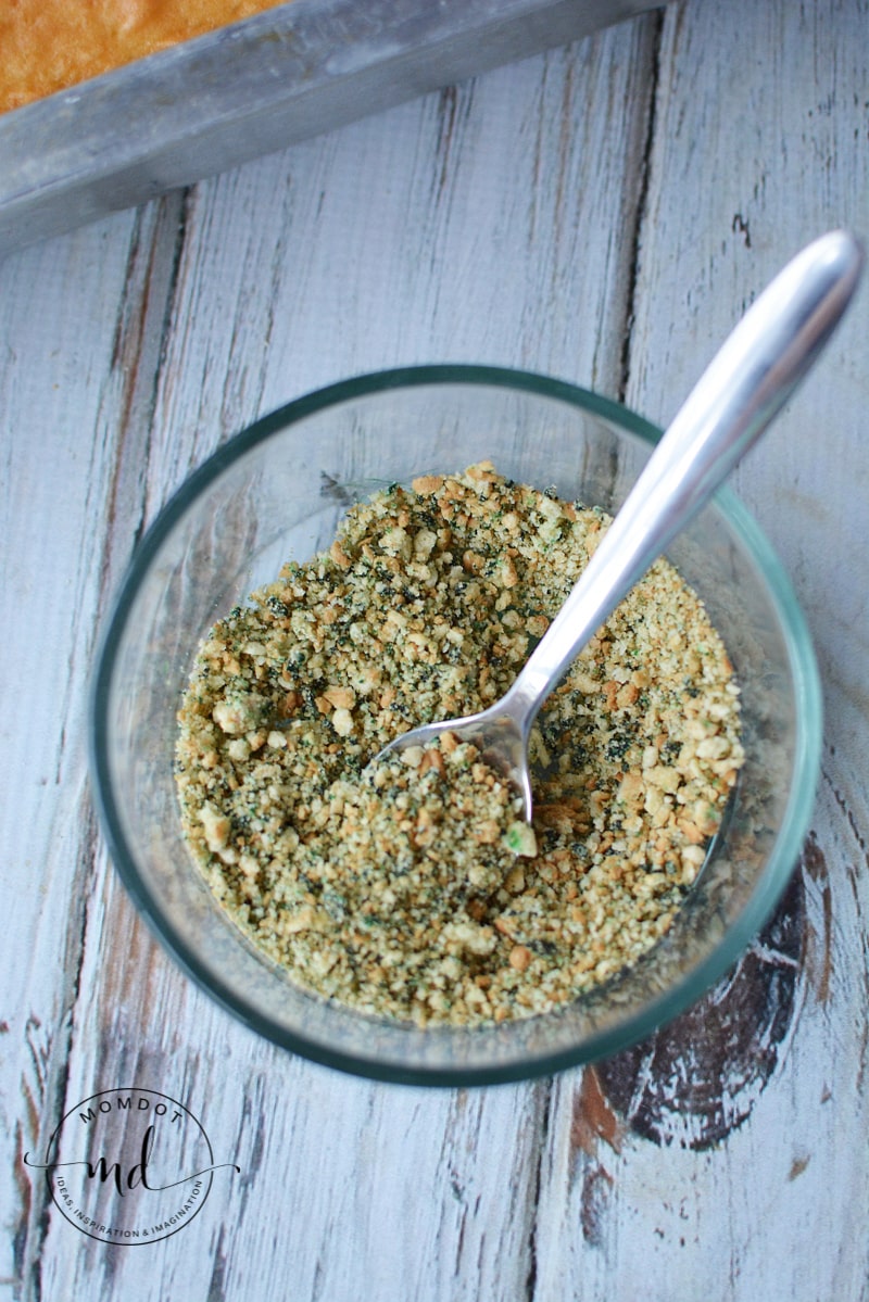 Vanilla wafer cookie crumbs in a bowl dyed green to make them look like dirty cat litter for the top of the cat litter cake.