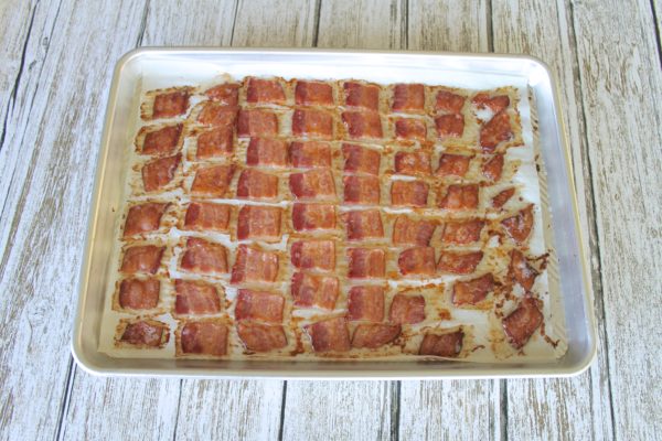 Bacon chips cooling on a baking sheet.