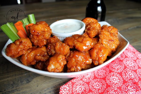 Copycat Asian Zing wings in a bowl with ranch dressing and a beer on the table.