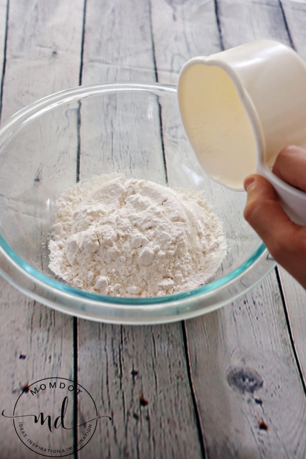 A cup of flour in a mixing bowl that will be used to make apple crisp topping.