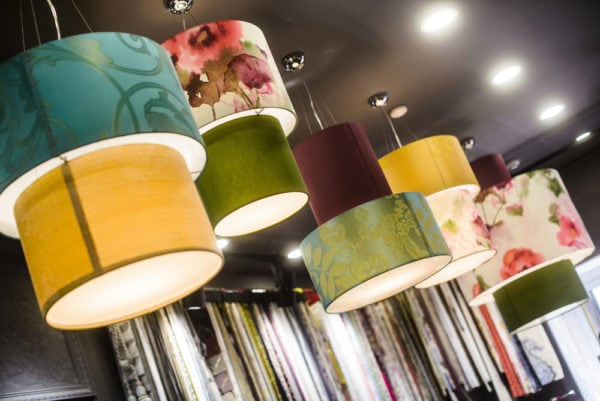 Fabric lampshades hanging from a store ceiling can be altered to include family photos for a sentimental DIY Christmas gift for mom.