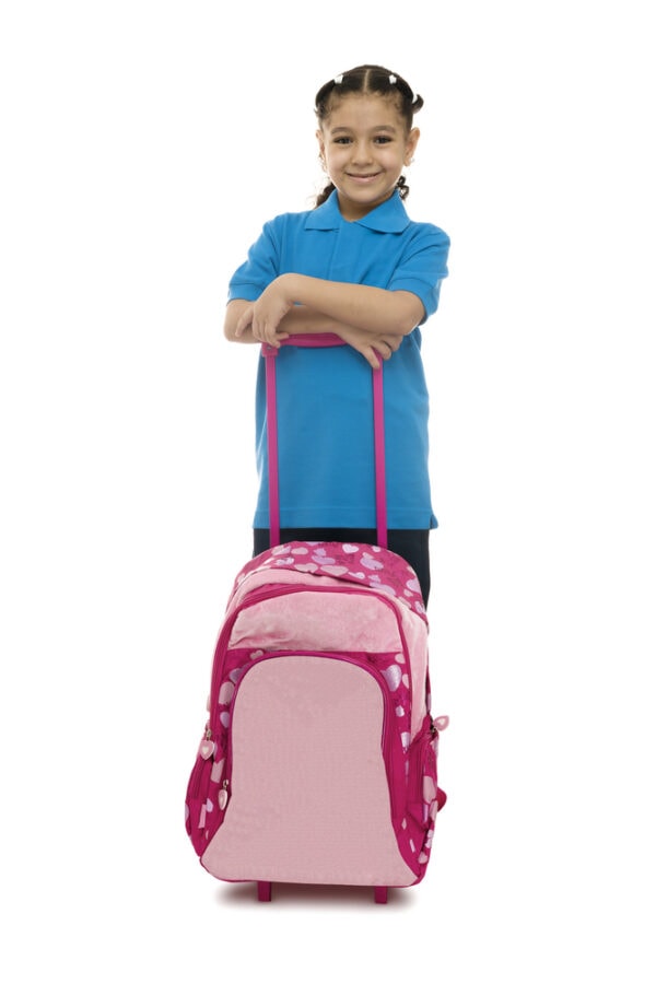 A girl with one of the best rolling backpacks for kids carrying her vacation supplies.