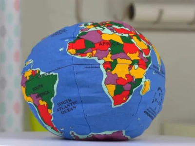 Hugg-a Planet Classic globe pillow has general political boundaries, bright colors, and continental names.
